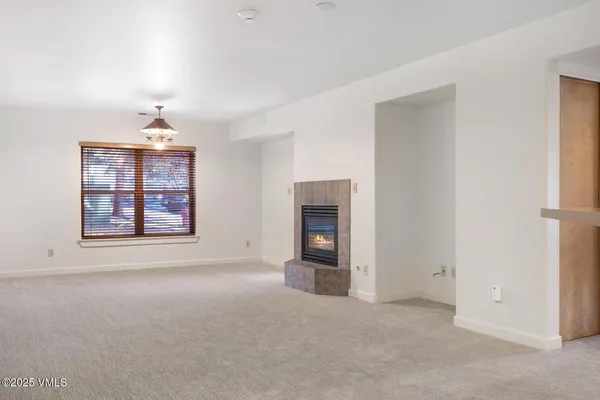 an empty room with windows and fireplace