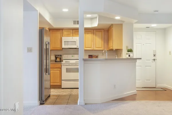 a open kitchen with white cabinets and white appliances