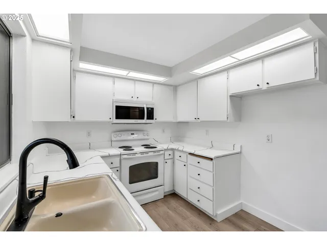 a kitchen with stainless steel appliances granite countertop a sink a stove and cabinets