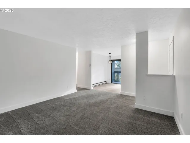a view of an empty room with kitchen
