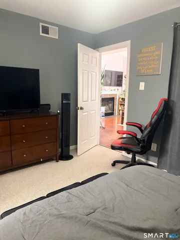 a bedroom with a bed and flat screen tv