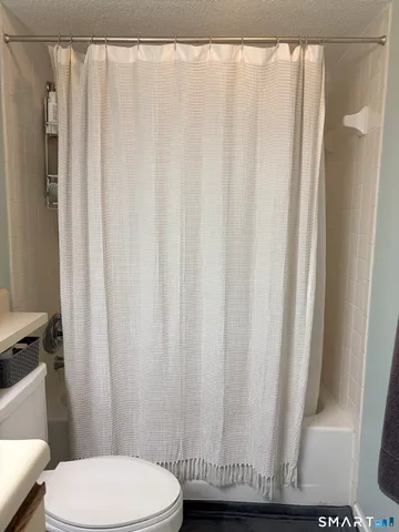 a bathroom with a toilet and a shower curtain