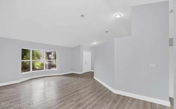 wooden floor in an empty room with a window