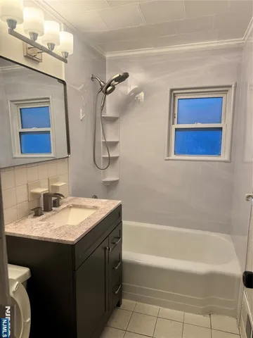 a bathroom with a granite countertop sink a mirror and a bathtub