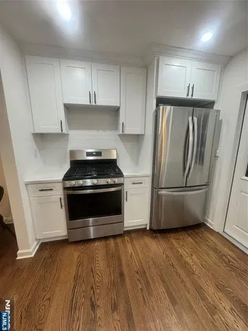 a kitchen with granite countertop a stove and a refrigerator