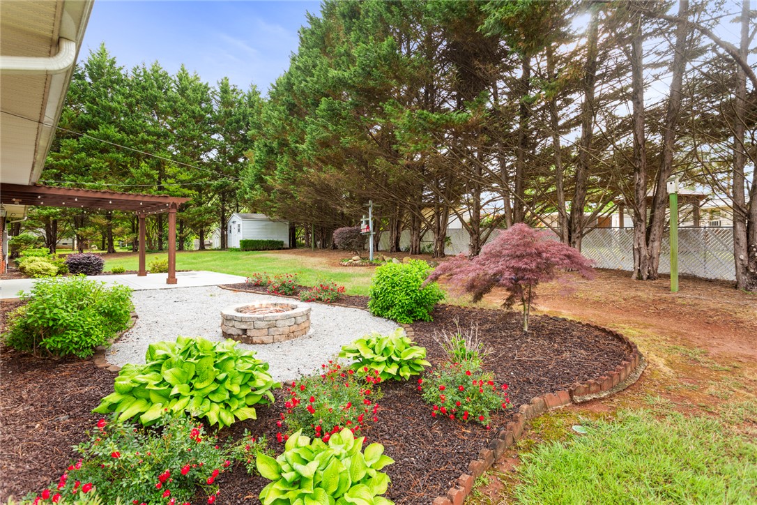 202 Keowee Trail Seneca, SC 29672 - Photo 31 of 35 This tranquil yard features lush landscaping, a fire pit, and a relaxing pergola.