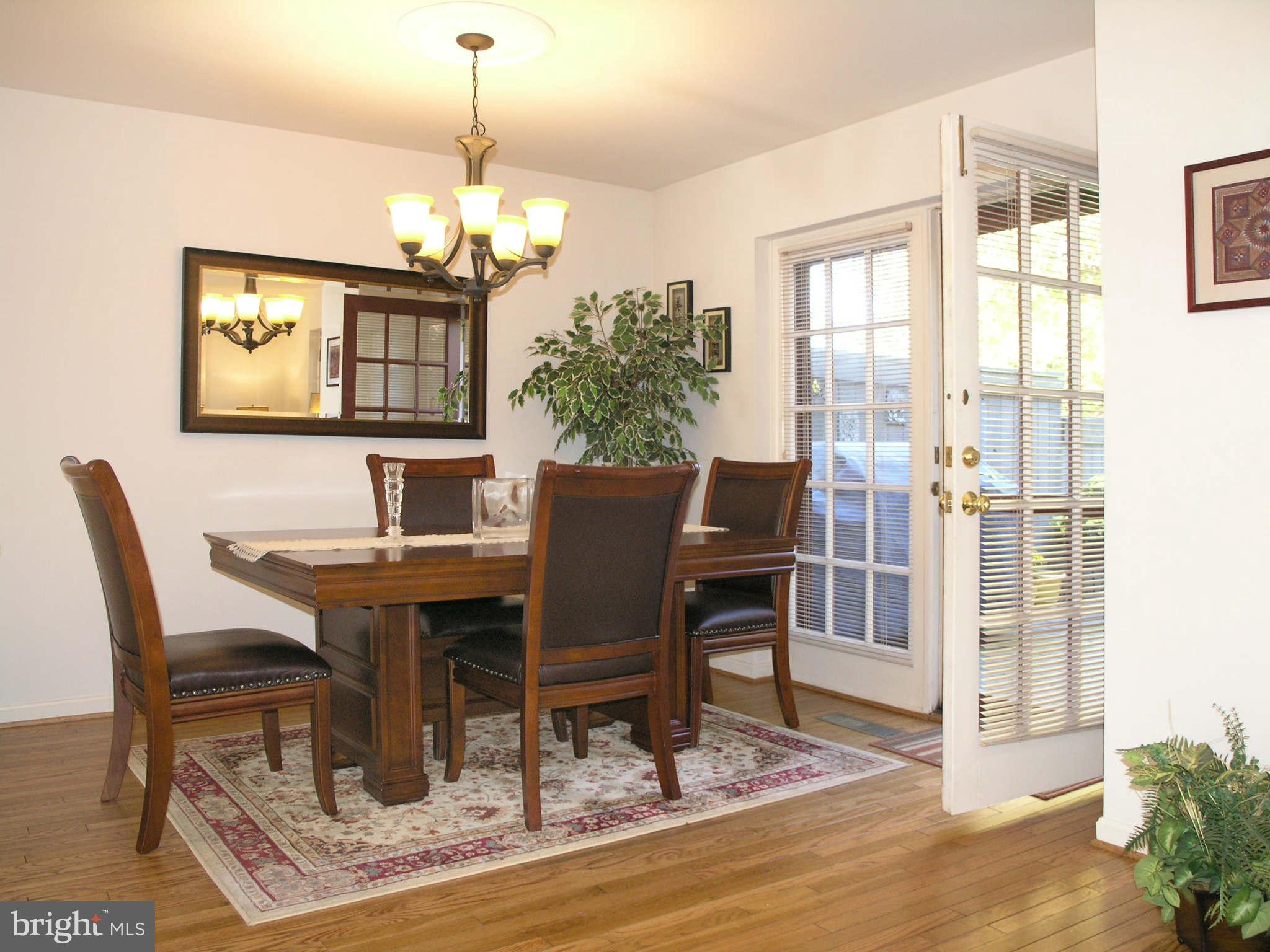 2168 Golf Course Drive Reston, VA 20191 - Photo 7 of 30 a dining room with furniture a chandelier and wooden floor