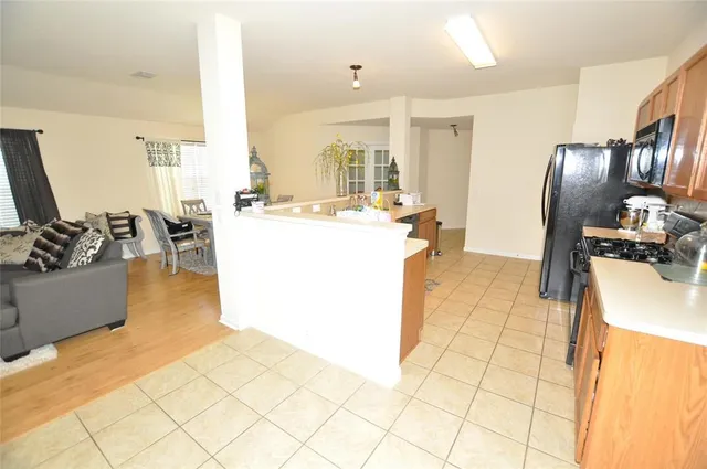 a kitchen with stainless steel appliances kitchen island granite countertop a refrigerator a stove top oven and a sink