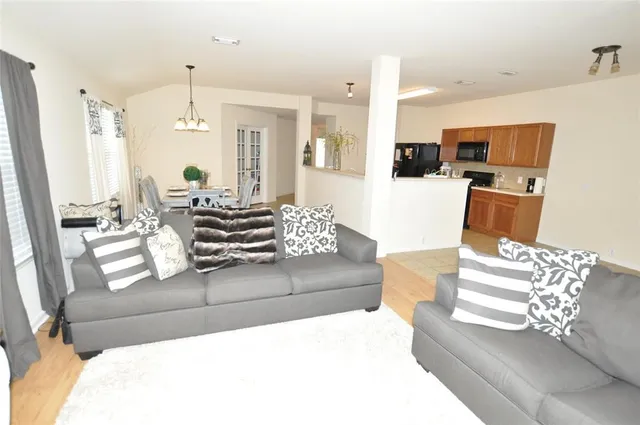 a living room with furniture and a chandelier