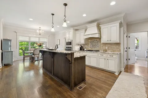 a kitchen with a sink stainless steel appliances and white cabinets