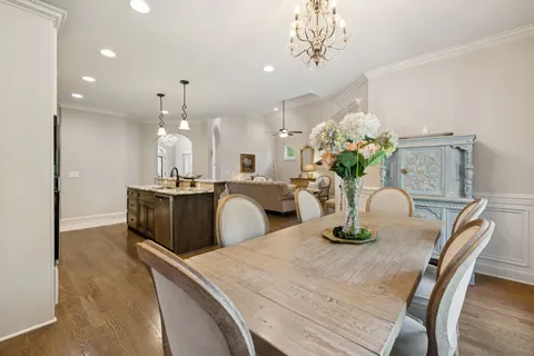 a dining room with furniture a chandelier and wooden floor