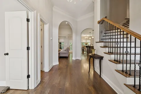 a view of a hallway with wooden floor and staircase