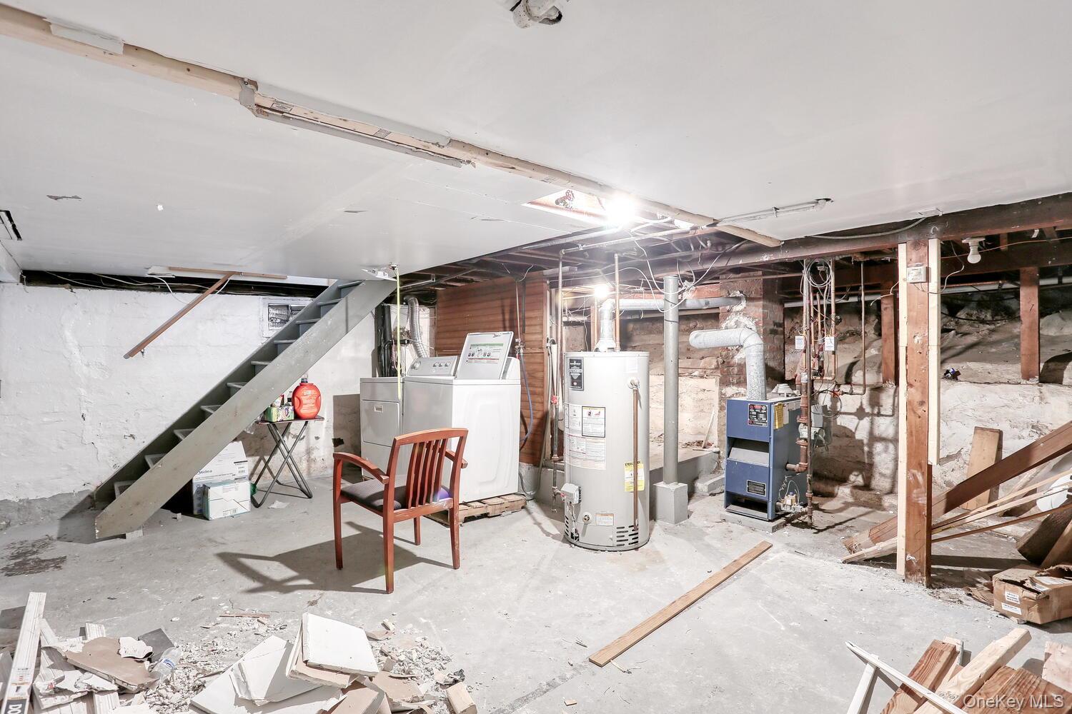 329 Call Hollow Road Haverstraw, NY 10980 - Photo 19 of 28 Unfinished basement with washing machine and dryer, stairs, water heater, and a heating unit