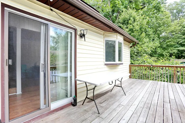 a balcony with wooden floor table and chairs