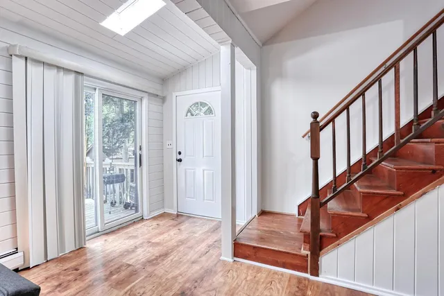 a view of an entryway with wooden floor and door
