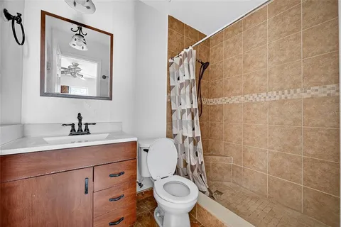 a bathroom with a granite countertop sink toilet and a shower