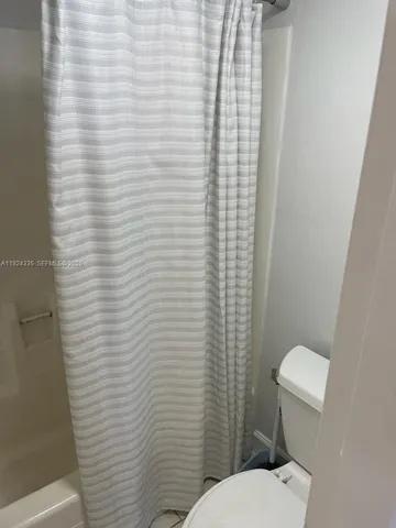 a white toilet sitting next to a white sink