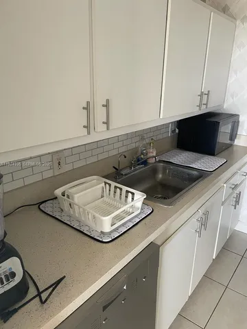 a kitchen with a sink a stove and cabinets