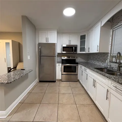 a spacious bathroom with a granite countertop sink and a mirror