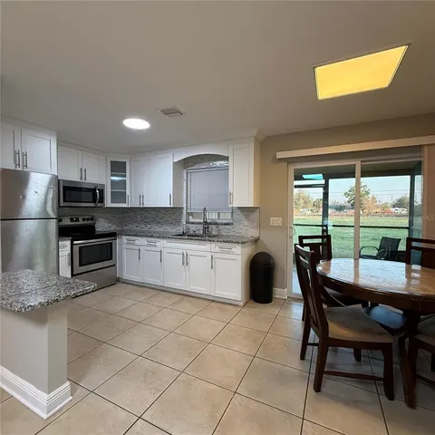 a kitchen with granite countertop white cabinets and white appliances