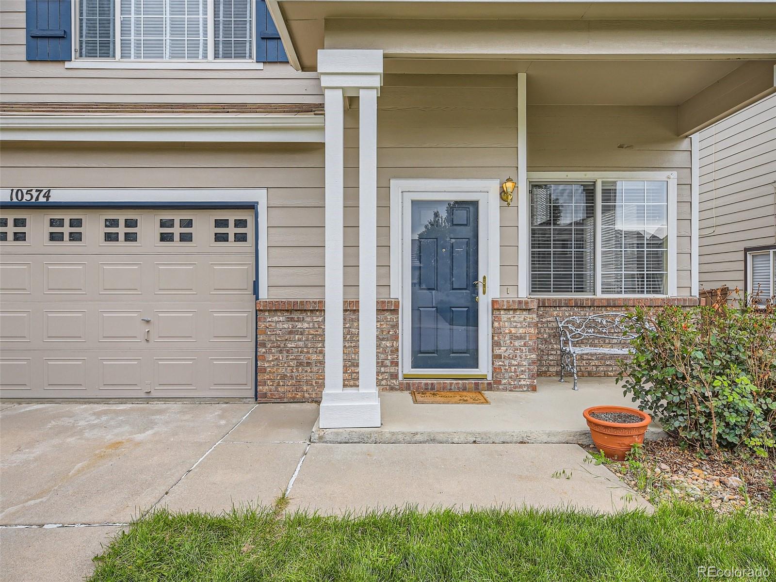10574 Tracewood Circle Highlands Ranch, CO 80130 - Photo 2 of 21 front view of a house with a bench in front of door