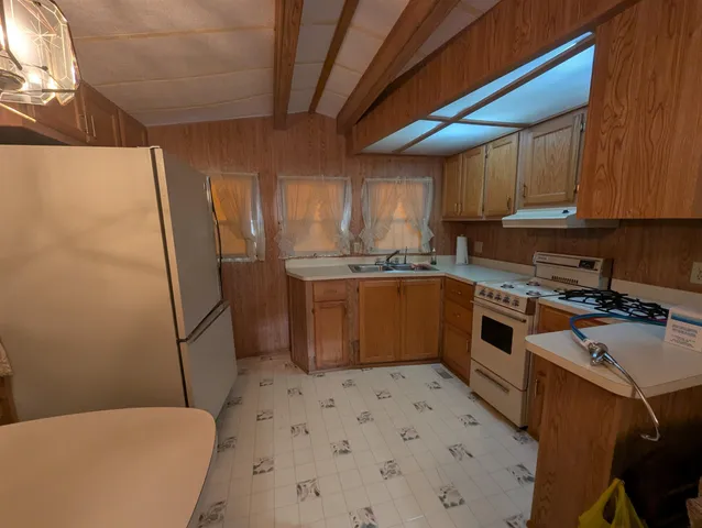 a kitchen with a sink a stove refrigerator and cabinets