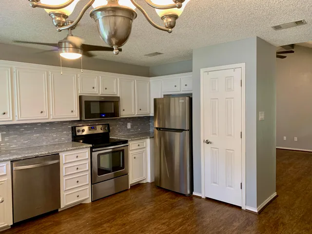 a kitchen with stainless steel appliances a refrigerator a stove a microwave and cabinets