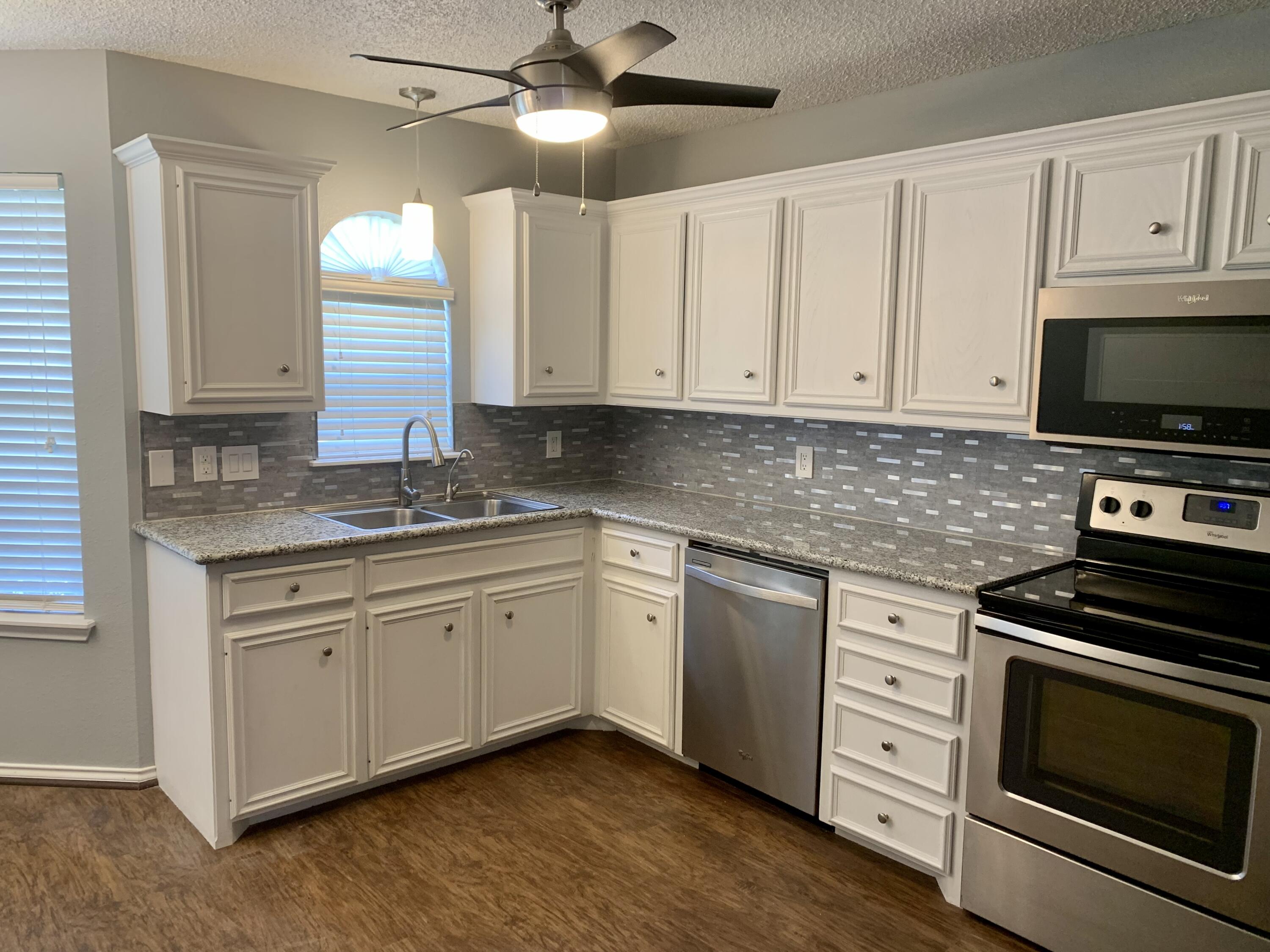 8904 Elgin Avenue Lubbock, TX 79423 - Photo 12 of 20 a kitchen with granite countertop cabinets stainless steel appliances and a window