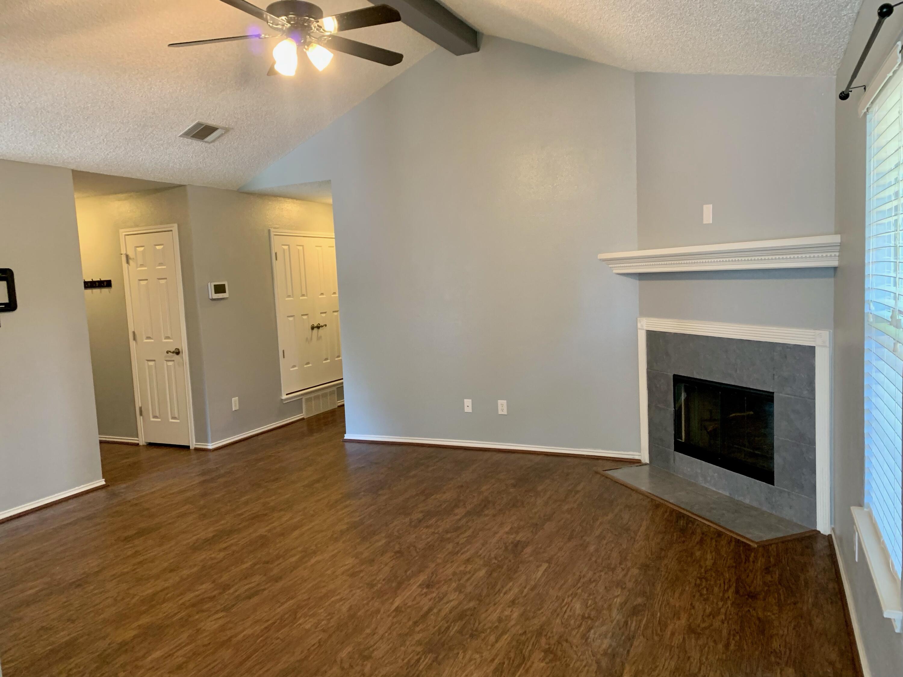 8904 Elgin Avenue Lubbock, TX 79423 - Photo 5 of 20 a view of an empty room with wooden floor and a fireplace