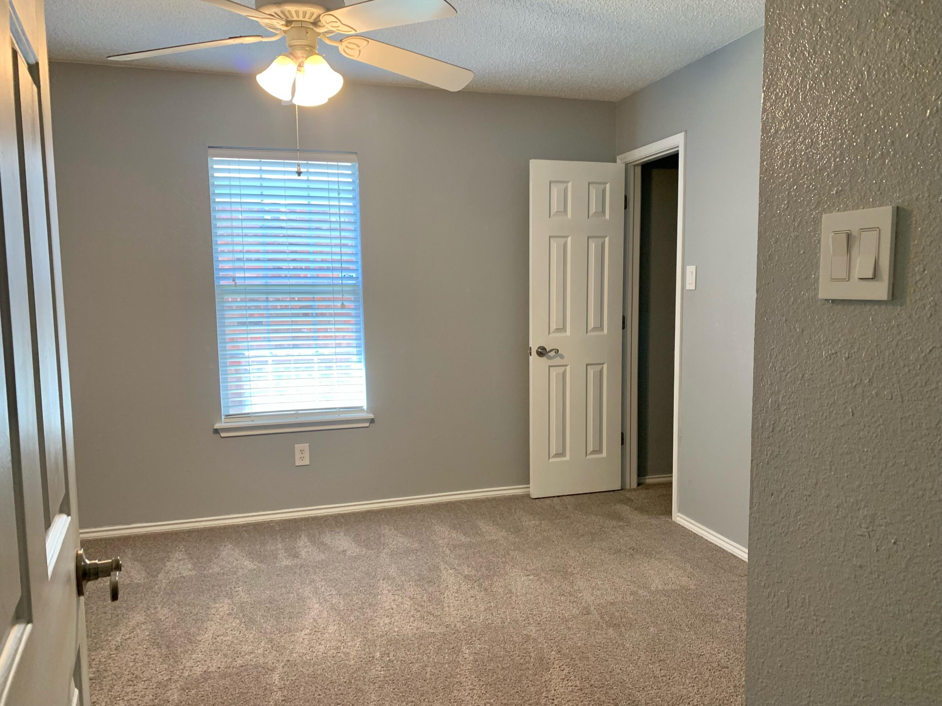 8904 Elgin Avenue Lubbock, TX 79423 - Photo 7 of 20 a view of an empty room with a window