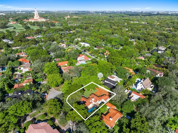 an aerial view of residential houses with outdoor space and trees