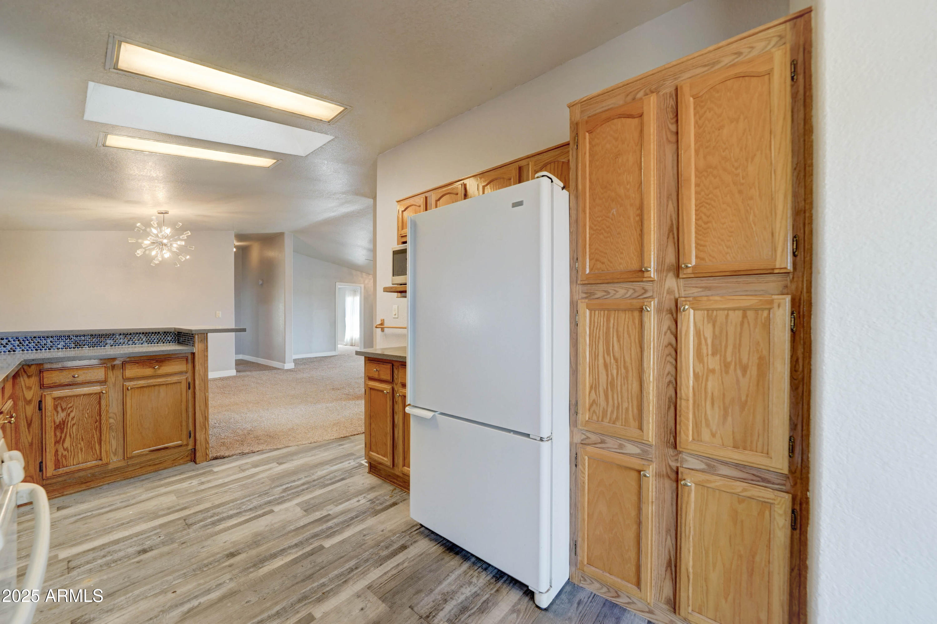 23402 South Manzanilla Road Buckeye, AZ 85326 - Photo 11 of 46 a view of a kitchen with a refrigerator and wooden floor