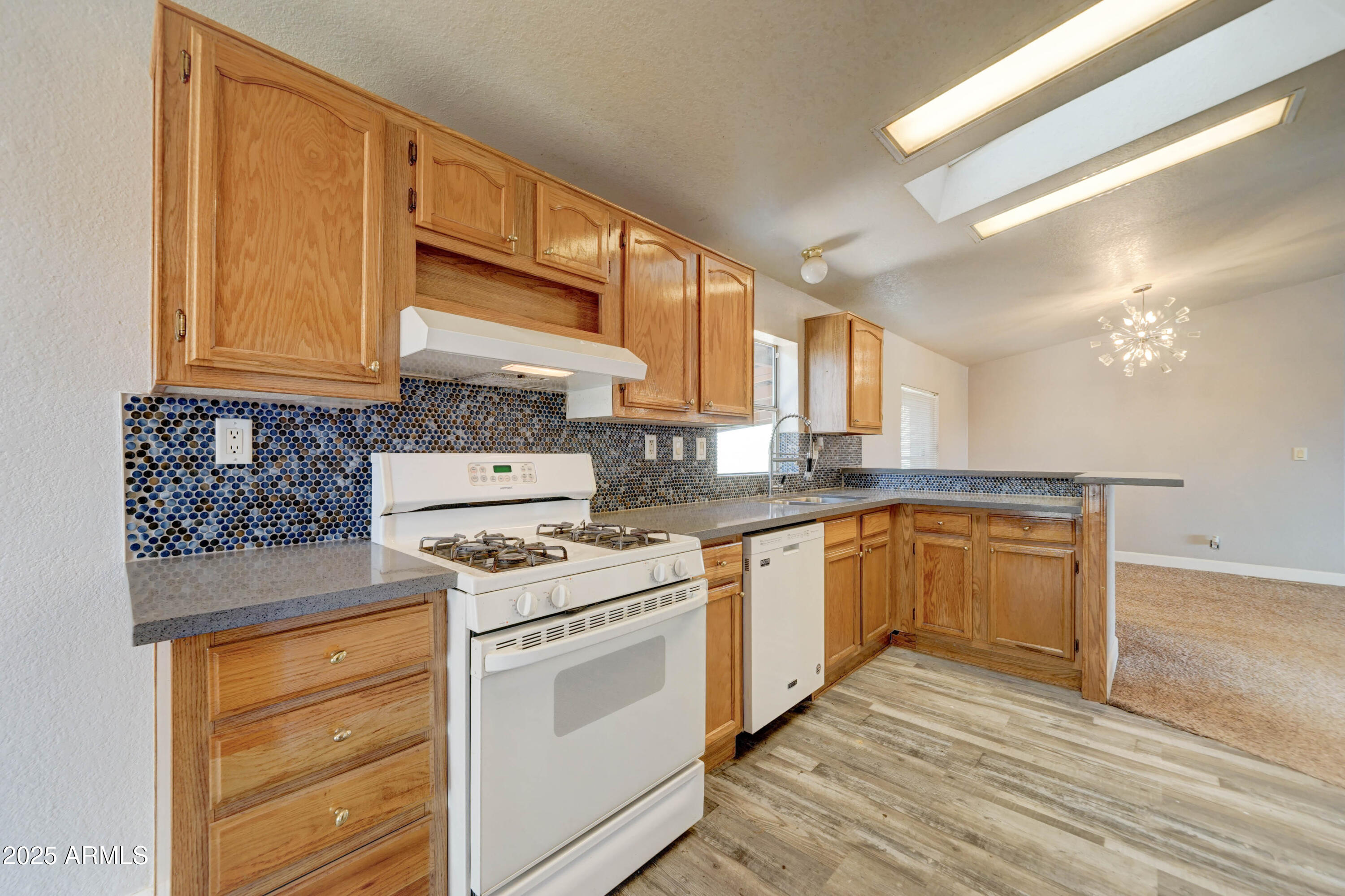 23402 South Manzanilla Road Buckeye, AZ 85326 - Photo 12 of 46 a kitchen with granite countertop cabinets stainless steel appliances and a wooden floor