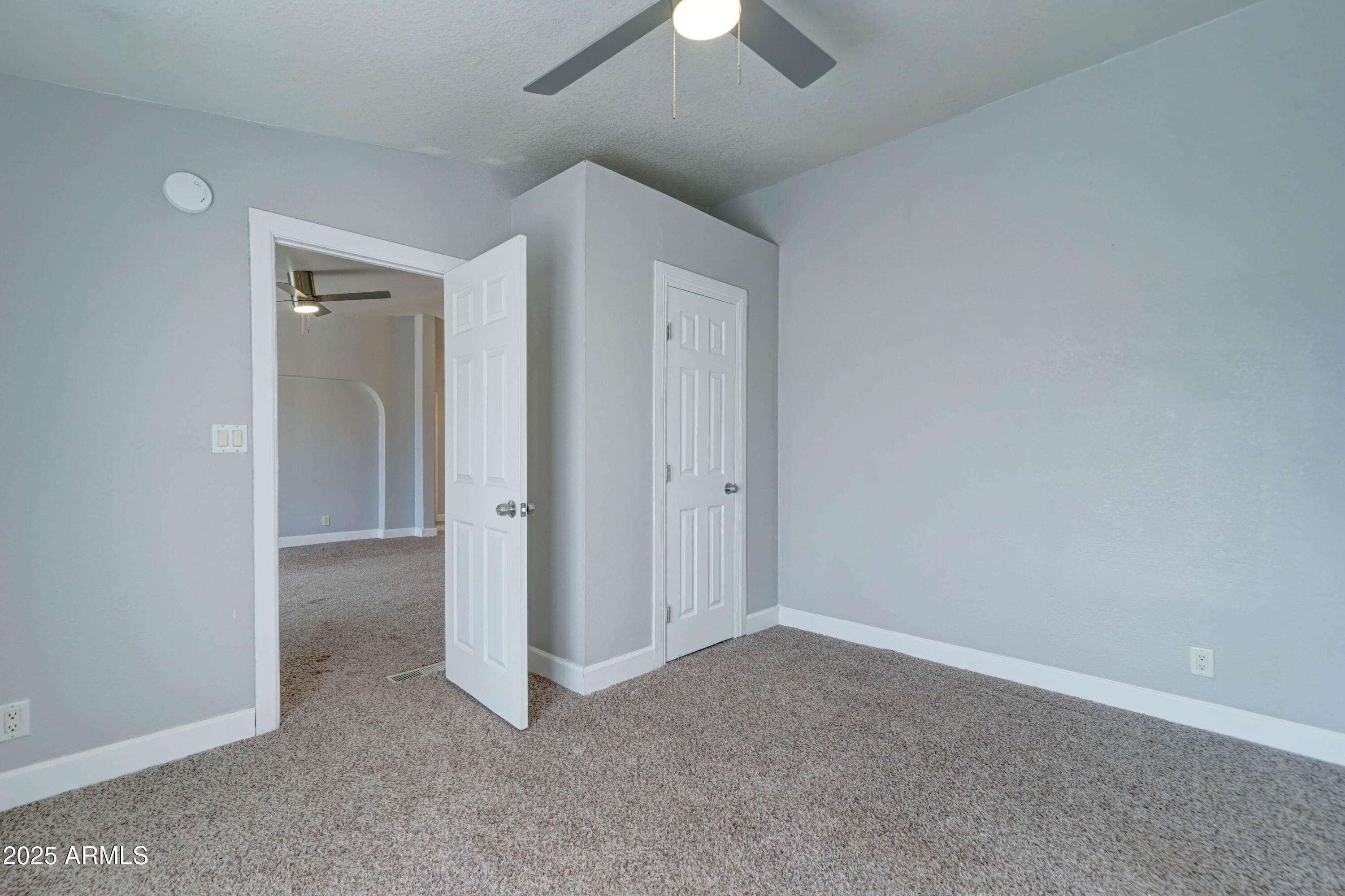 23402 South Manzanilla Road Buckeye, AZ 85326 - Photo 18 of 46 an empty room with a hallway and a chandelier fan