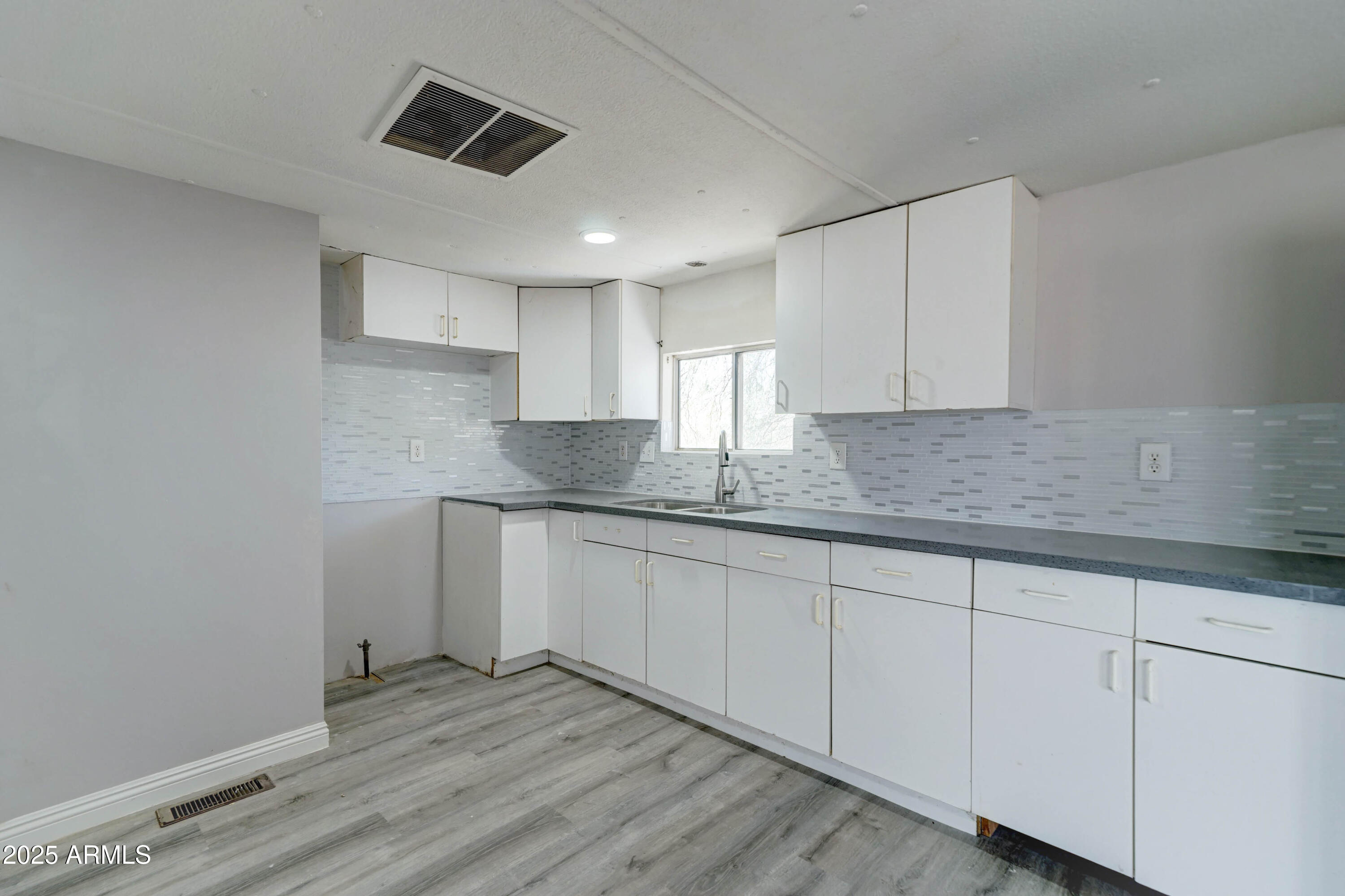 23402 South Manzanilla Road Buckeye, AZ 85326 - Photo 34 of 46 a kitchen with granite countertop white cabinets sink and stainless steel appliances