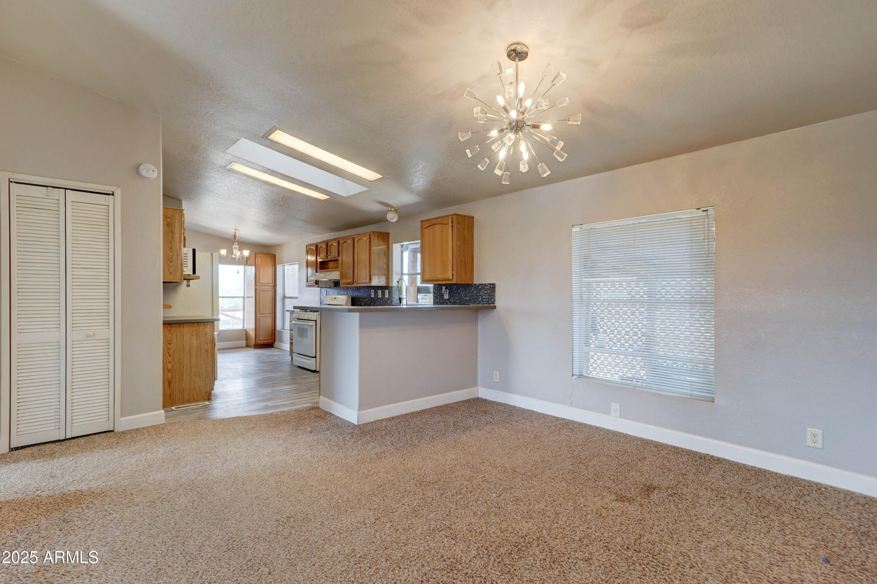 23402 South Manzanilla Road Buckeye, AZ 85326 - Photo 7 of 46 a view of a room with a kitchen and chandelier