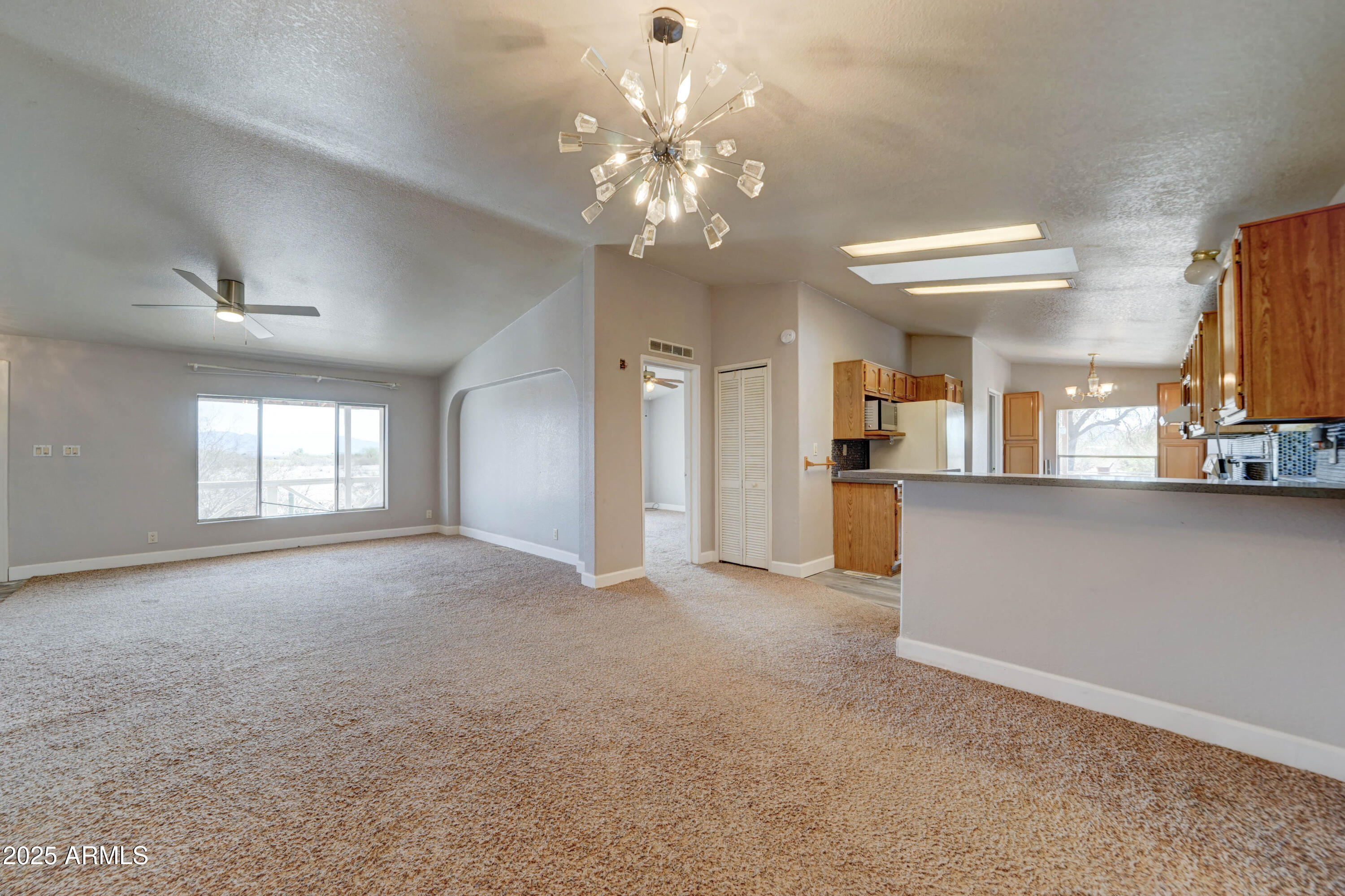 23402 South Manzanilla Road Buckeye, AZ 85326 - Photo 8 of 46 a view of a big room with chandelier and windows