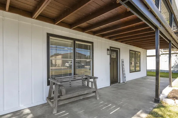 a view of a porch with chairs and wooden floor