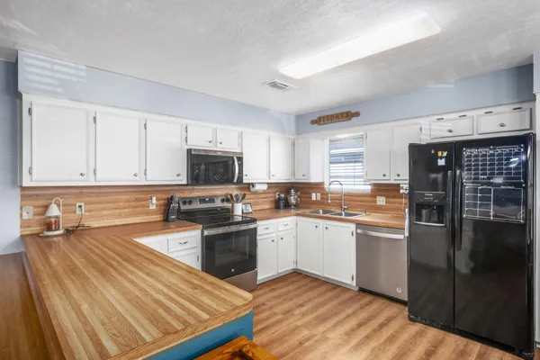 a kitchen with stainless steel appliances granite countertop a stove a sink and a refrigerator