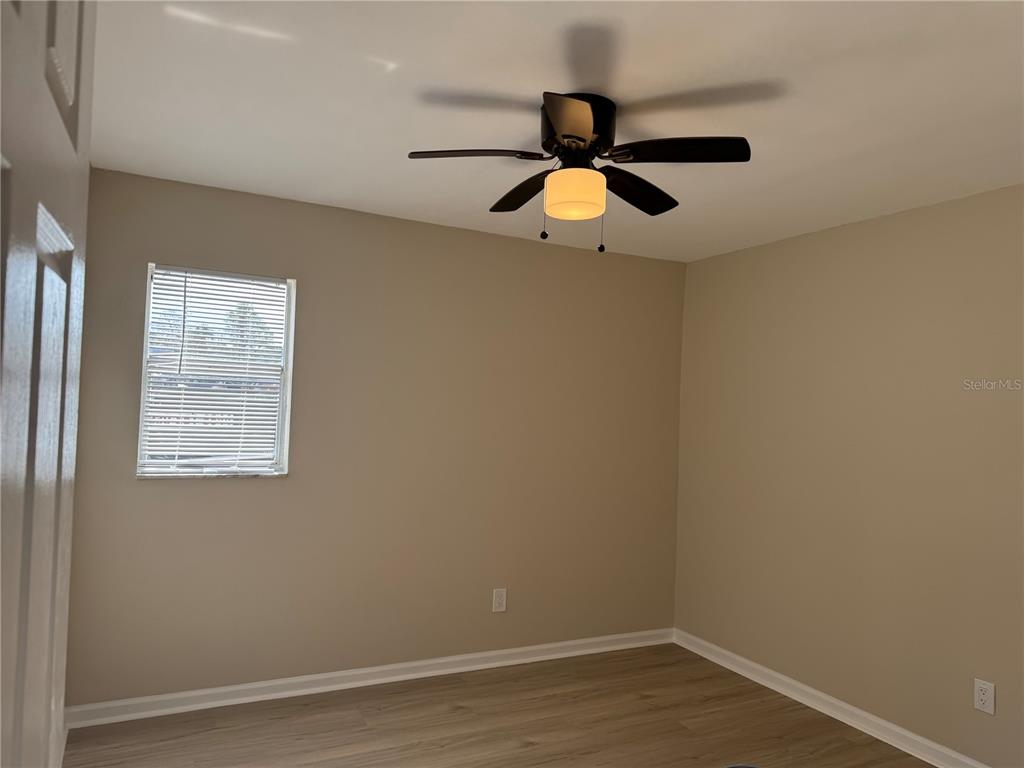 5521 Bay Boulevard, Unit 105 Port Richey, FL 34668 - Photo 11 of 15 an empty room with wooden floor and windows