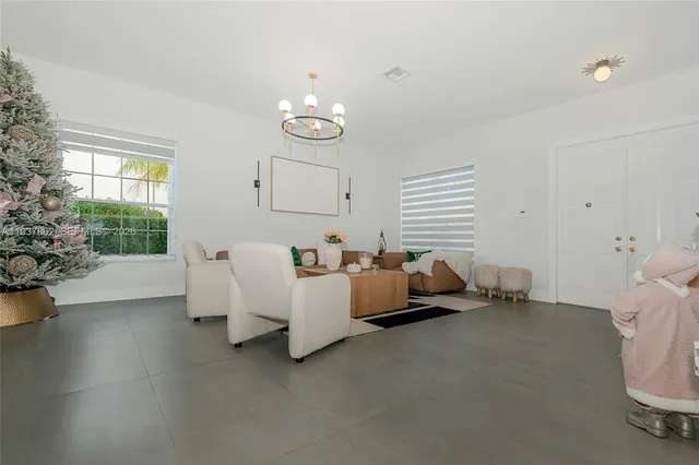 a living room with furniture and a view of kitchen