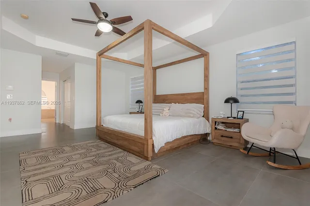 a bedroom with a bed and a flat tv screen on dresser