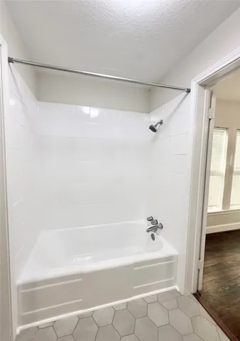 a bathroom with a shower and a bath tub