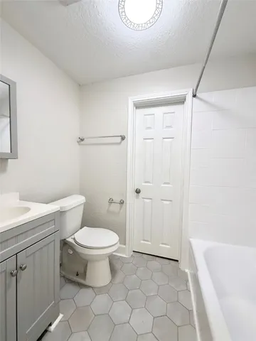 a bathroom with a toilet a sink a mirror and bathtub