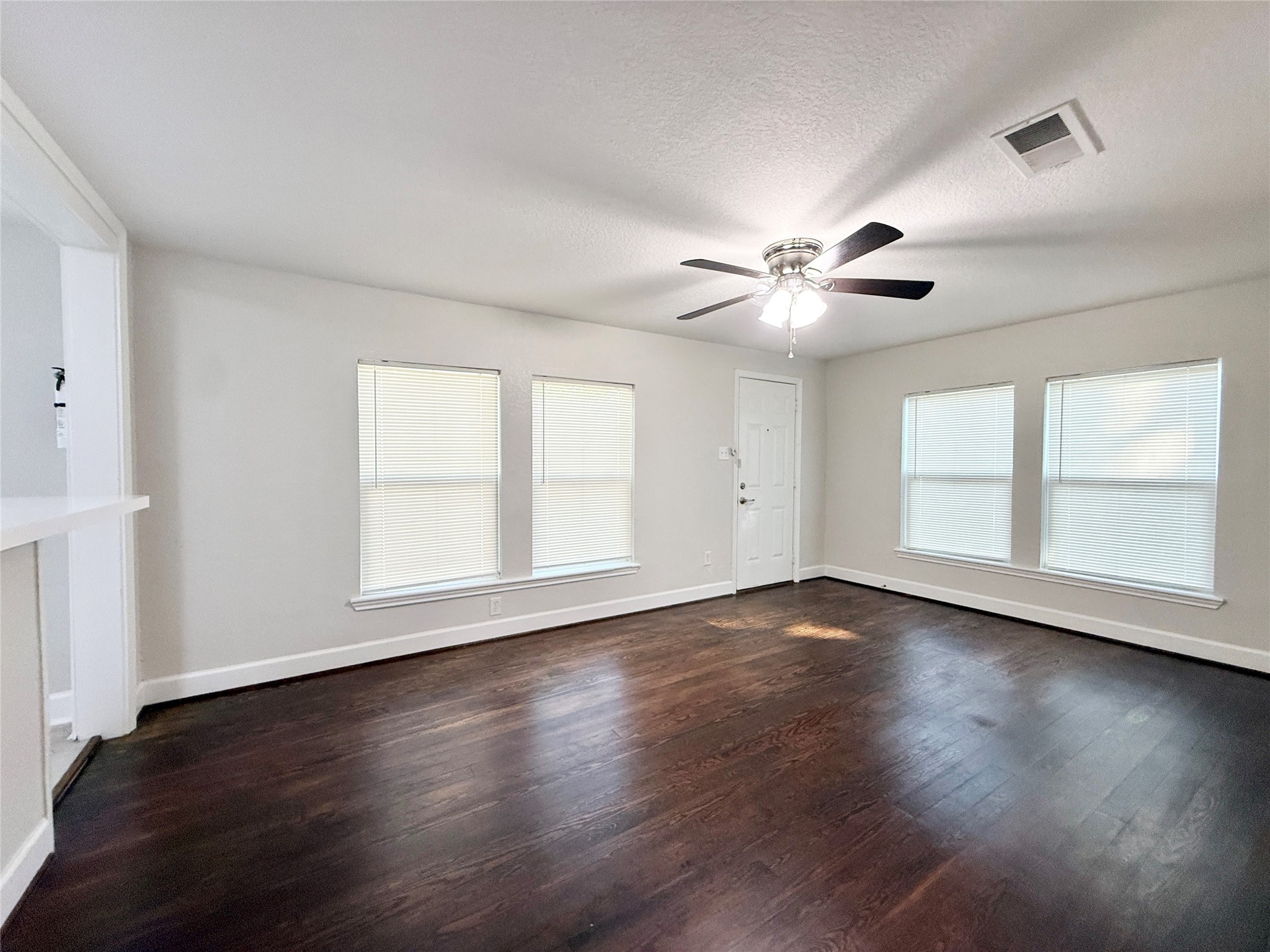 620 East Magnolia Street Angleton, TX 77515 - Photo 7 of 20 a view of an empty room with wooden floor and a window