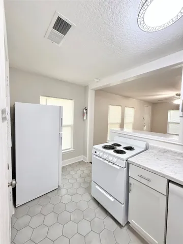 a kitchen with white cabinets and white appliances