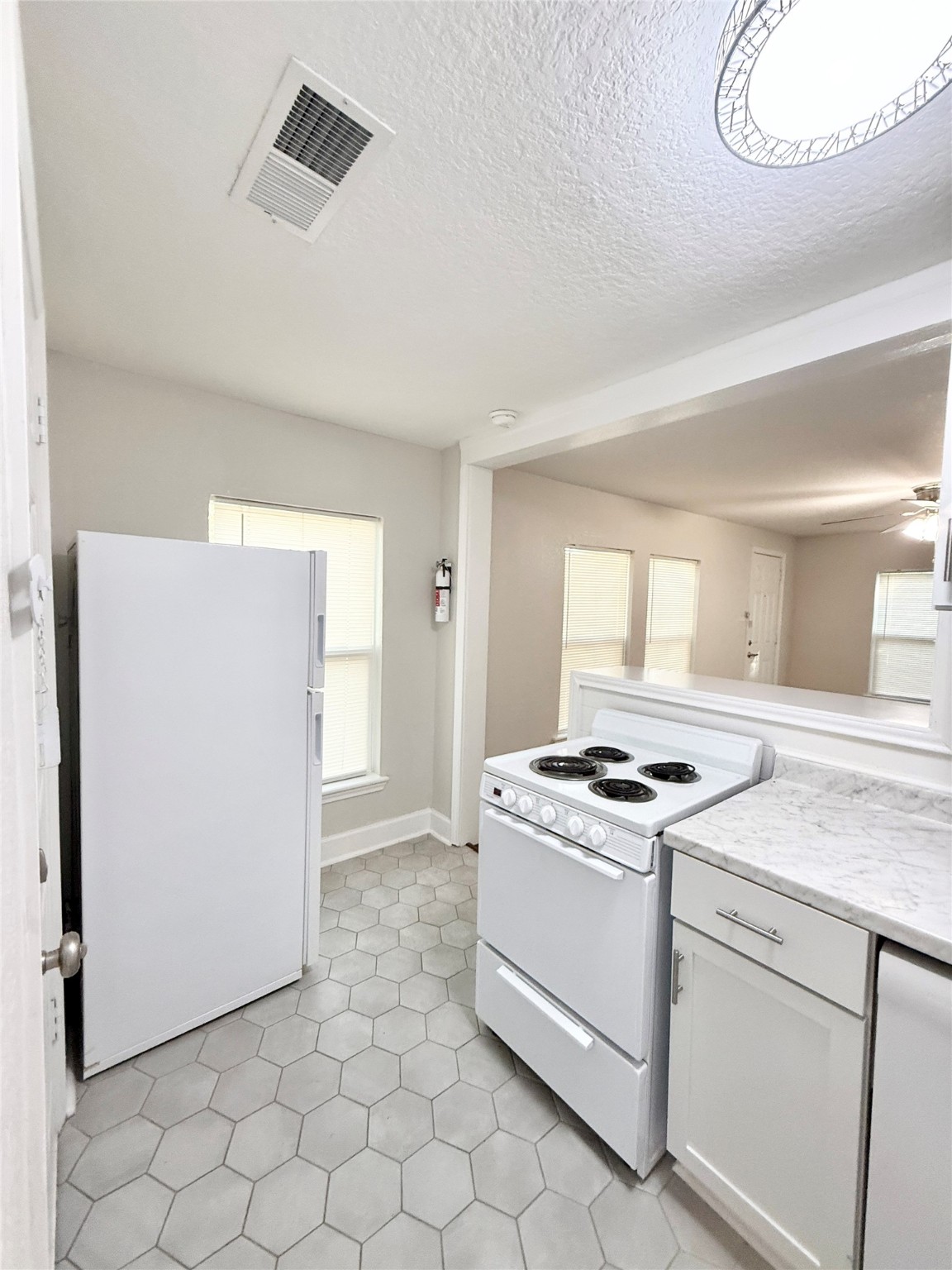 620 East Magnolia Street Angleton, TX 77515 - Photo 10 of 20 a kitchen with white cabinets and white appliances