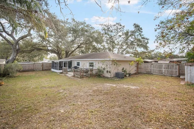 a view of a house with backyard and tree