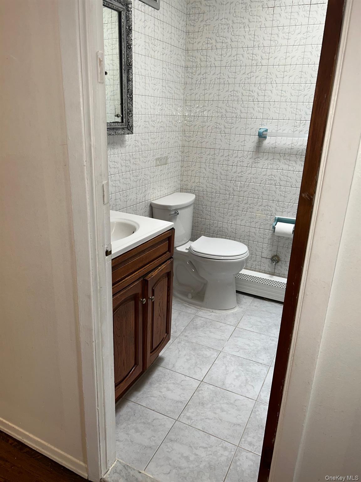 142-22 Pershing Crescent Queens, NY 11435 - Photo 11 of 11 a bathroom with a toilet a sink a mirror and a shower