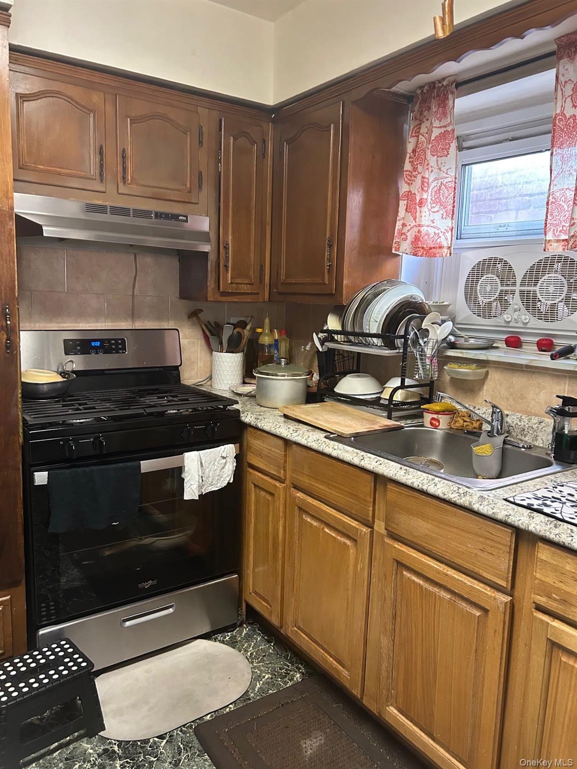 142-22 Pershing Crescent Queens, NY 11435 - Photo 6 of 11 a kitchen with granite countertop a stove and a sink